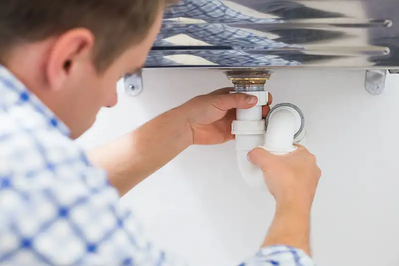 A plumber cleaning a sink drain